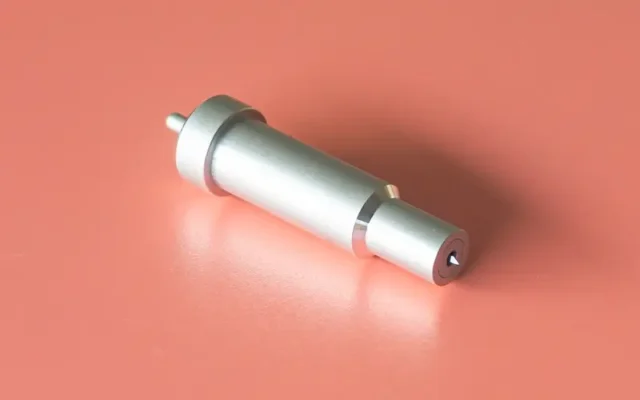 Cricut blade housing lying on a coral surface