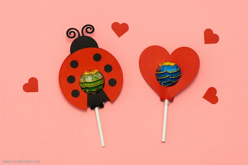 Valentine lollipop holders shaped like a ladybug and a red heart on a pink background