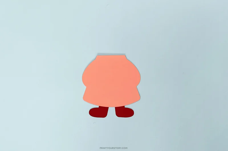 Valentine gnome craft with a pink paper body and red boots on blue paper