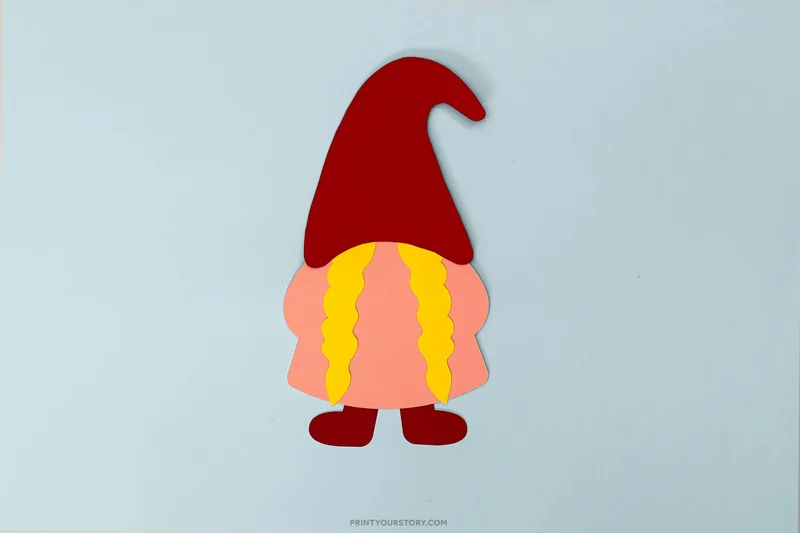 Valentine paper gnome craft with red hat, pink beard, yellow braids, and red feet