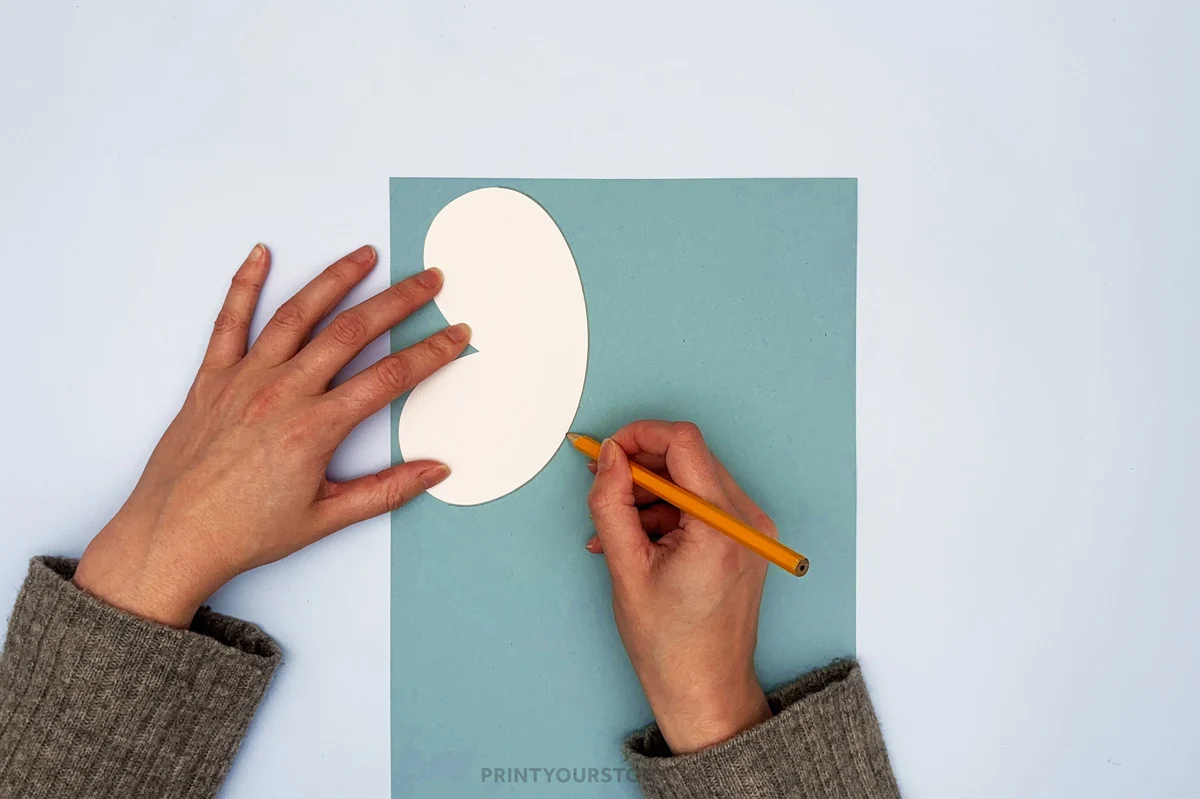 Hand tracing bee wing on blue paper for bee paper plate craft