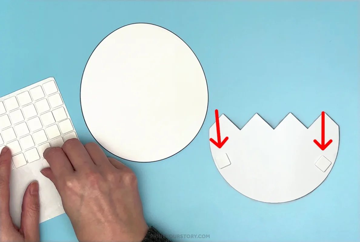 Adding adhesive foam squares to the cracked egg pieces for a hatching chick craft