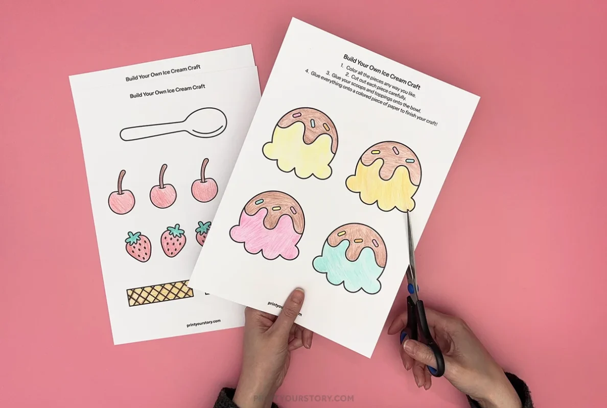 Cutting out colored ice cream sundae craft printable pieces with scissors on a pink background