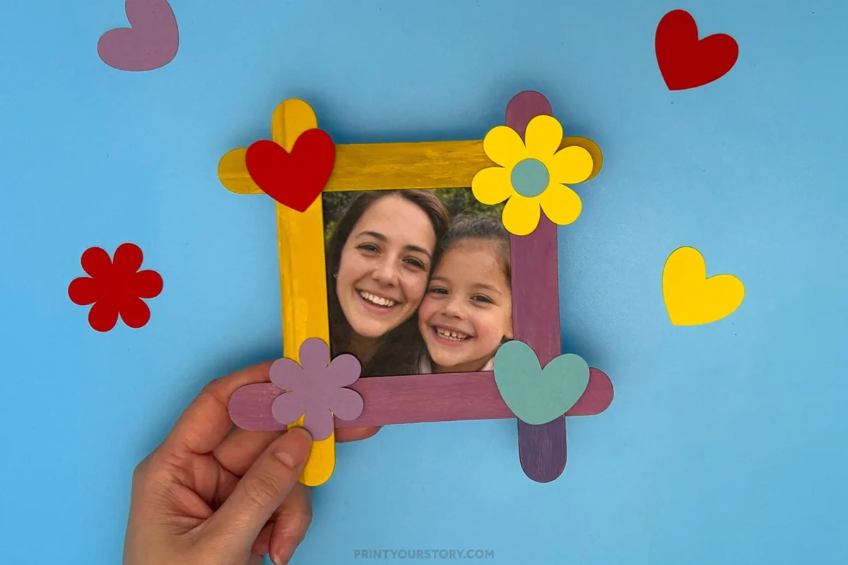 Popsicle stick Mother’s Day photo frame decorated with paper hearts and flowers