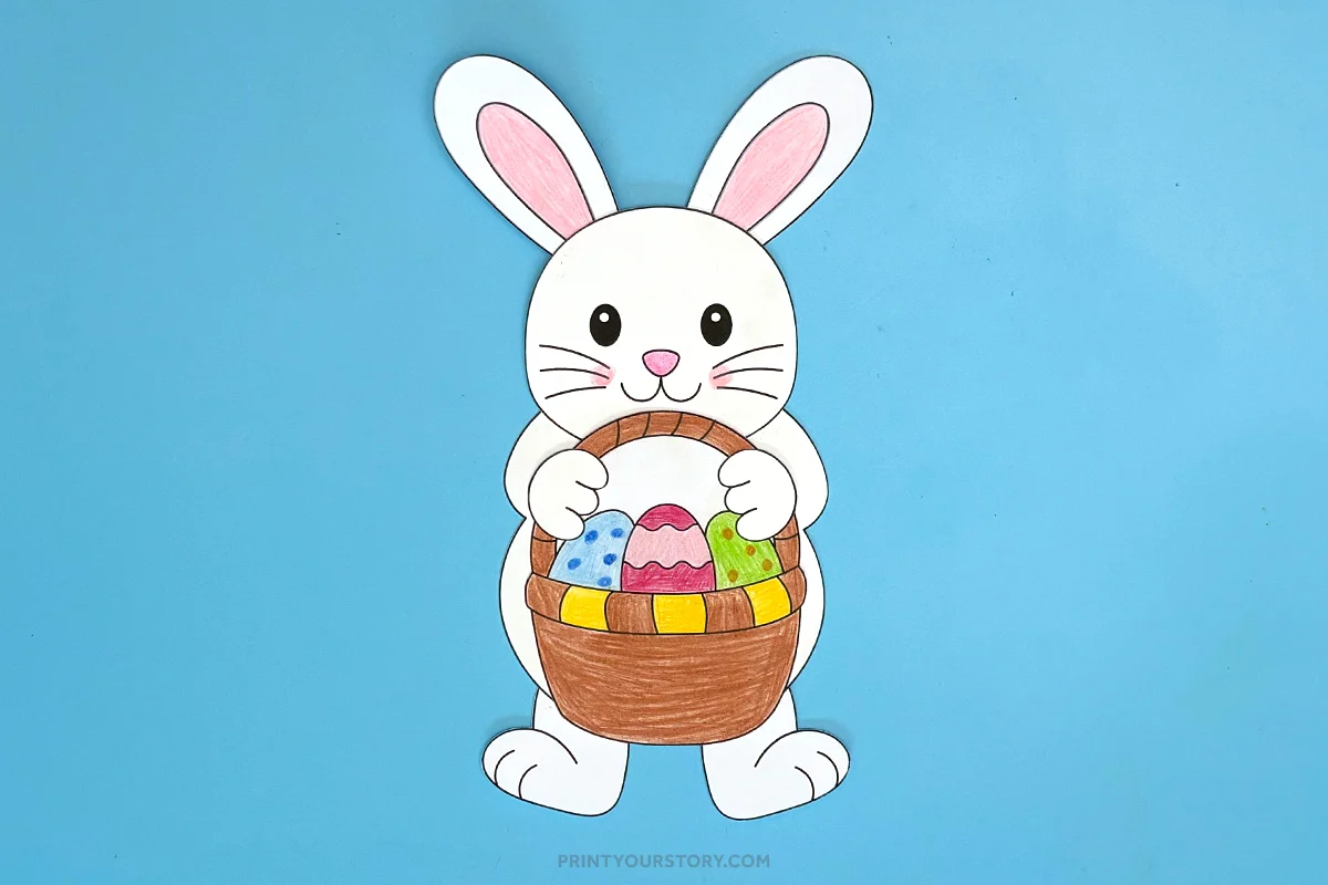 Completed paper Easter bunny craft holding a basket of colorful eggs on a blue background