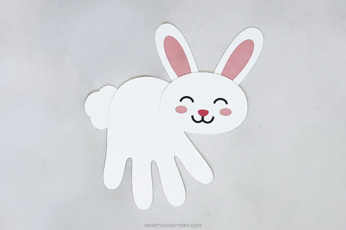 Paper handprint bunny craft with pink ears, face, and fluffy tail