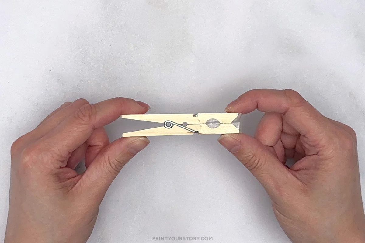 Wooden clothespin shown from the side for assembling a printable shark puppet craft