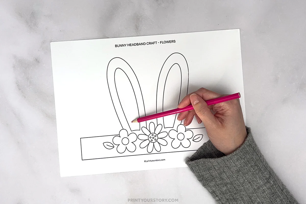 Hand coloring a printable bunny headband craft worksheet with bunny ears and flowers