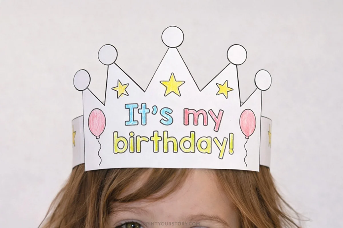 Child wearing a colored paper birthday crown headband that says “It’s my birthday!”