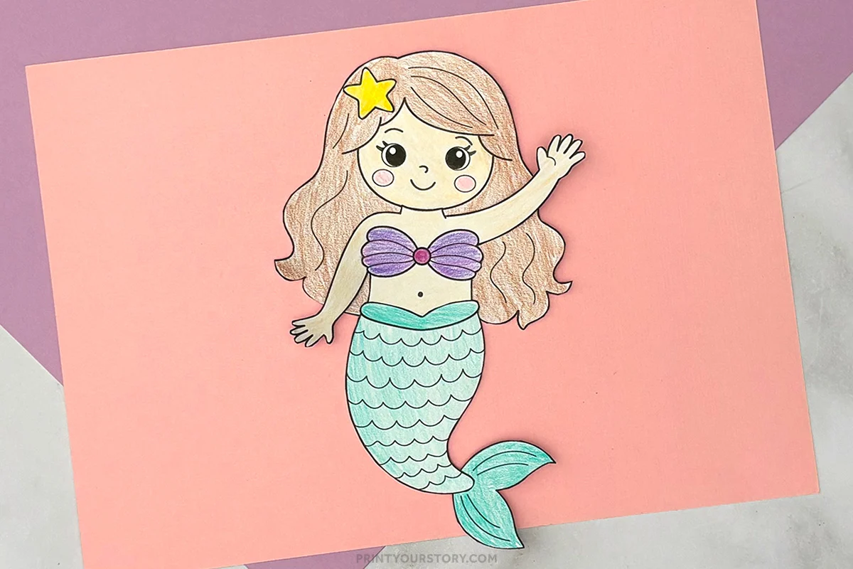 Colored printable mermaid craft with teal tail, purple shell top, and star hair clip on pink paper