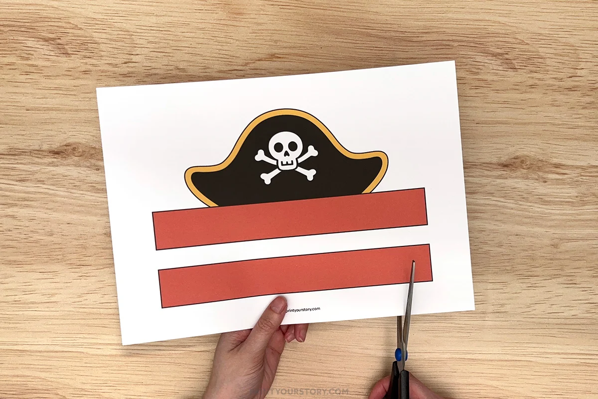 Cutting out red strips from a printable pirate hat craft template