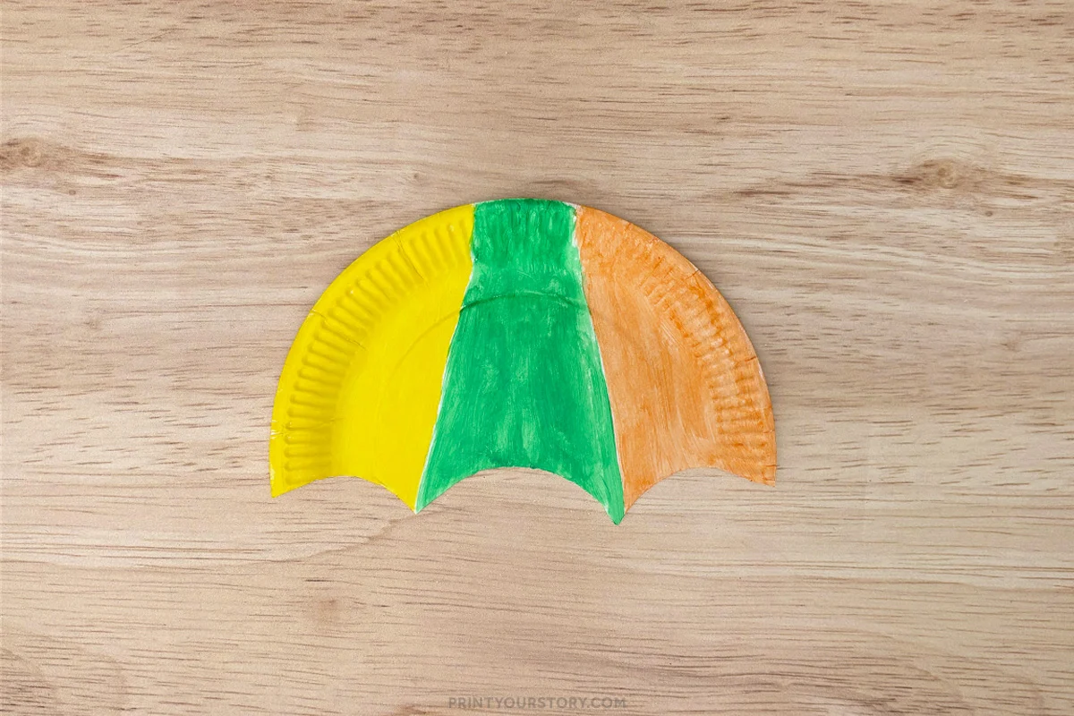 Cut paper plate umbrella canopy painted yellow, green, and orange