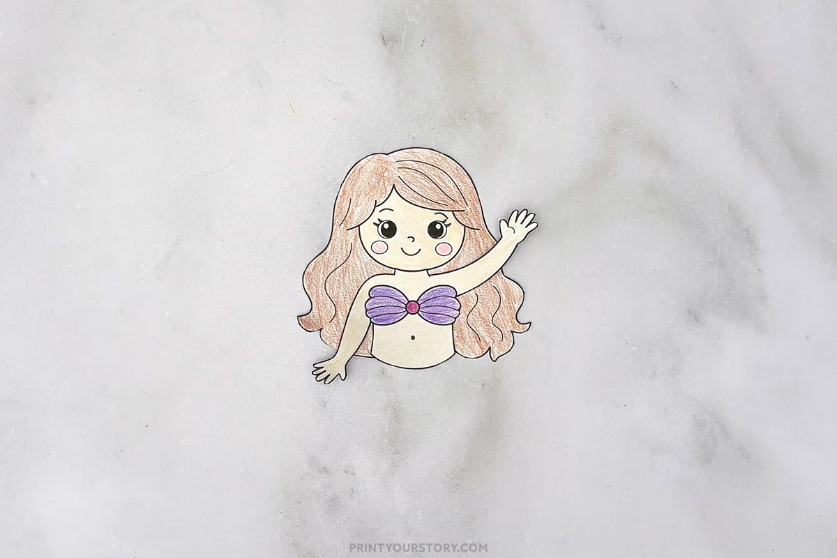 Colored paper mermaid craft torso with long hair, raised arm, and purple shell top