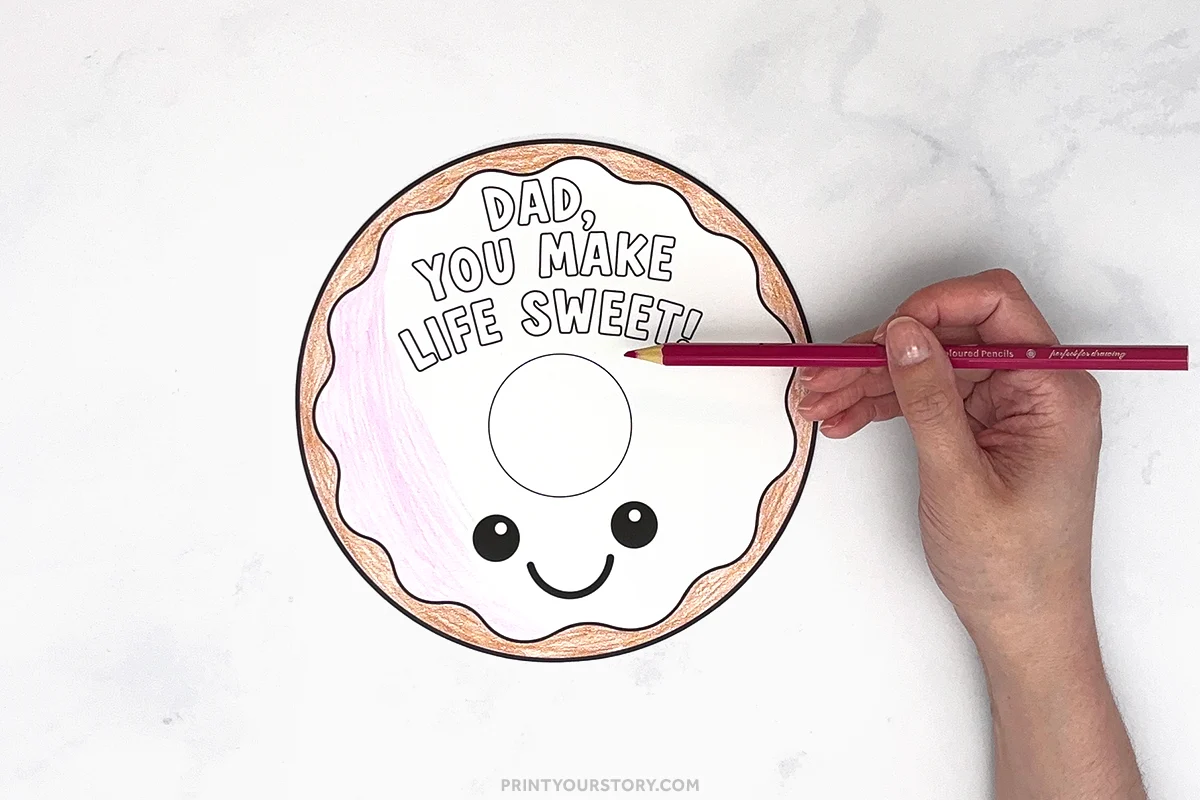 Hand coloring a Father’s Day donut printable that says “Dad, you make life sweet!”