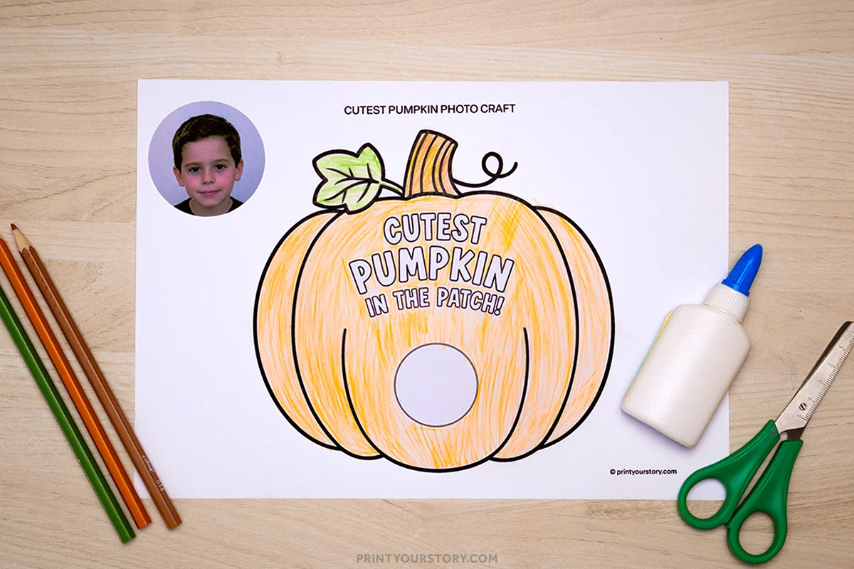 Pumpkin photo craft printable with a colored pumpkin cutout, child photo, colored pencils, glue, and scissors