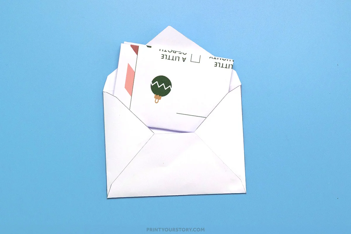 Printable letter to Santa and matching envelope partially tucked into a white envelope on a blue background